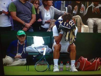 Feliciano Lopez con la testa nell'asciugamano dopo aver perso il secondo set. Dietro a lui, Ubaldo Scanagatta